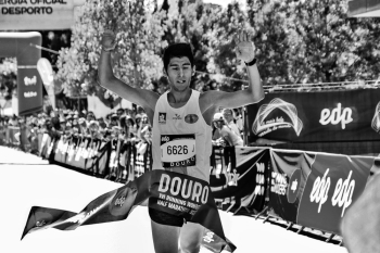 Grayscale Photo of Man at the finish line of a marathon race Grayscale Photo of Man at the finish line of a marathon race