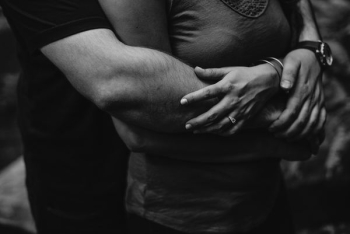 grayscale photo of man hugging a woman grayscale photo of man hugging a woman