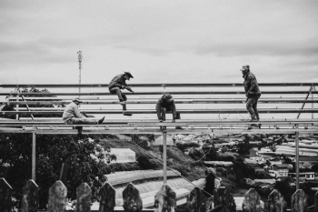Grayscale Photo of Men Working on a Scaffolding Grayscale Photo of Men Working on a Scaffolding