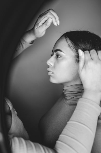 grayscale photo of person holding woman's hair