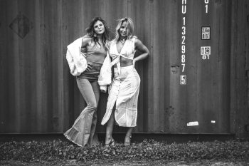Grayscale Photography of Two Women Standing Near Intermodal Container Grayscale Photography of Two Women Standing Near Intermodal Container