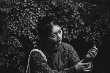 grayscale photography of woman holding leaf grayscale photography of woman holding leaf