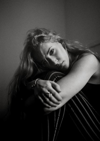 grayscale photography of woman sitting inside room