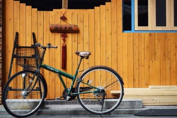 green bike beside wooden wall green bike beside wooden wall