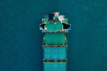 green cargo ship on body of water green cargo ship on body of water