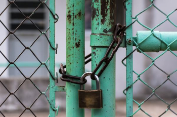 green metal gate with brown metal padlock green metal gate with brown metal padlock