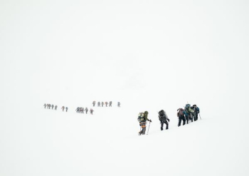 group of mountaineers hiking on snowy mountain group of mountaineers hiking on snowy mountain