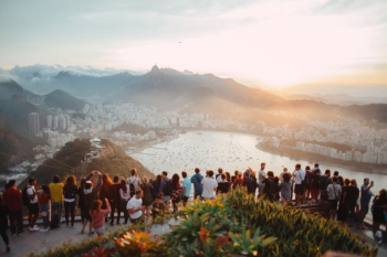 group of people standing facing lake view group of people standing facing lake view