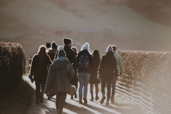 group of people wearing jackets while walking