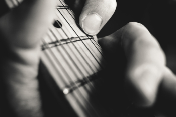 Guitarist hand playing guitar closeup Guitarist hand playing guitar closeup
