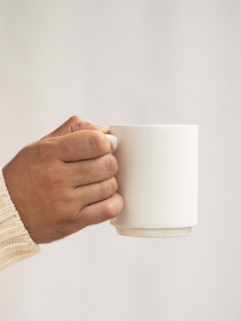 Hand holding a mug mock-up Free Photo