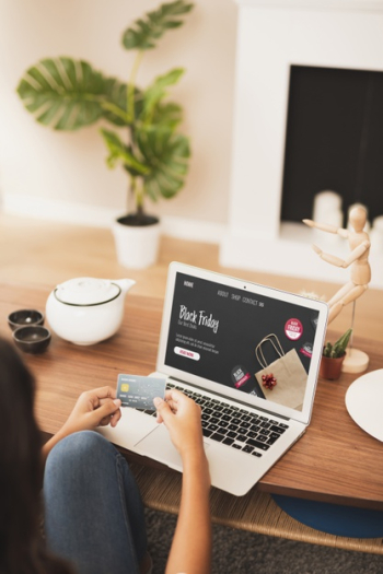 Hands holding a credit card next to a laptop mock up Free Photo