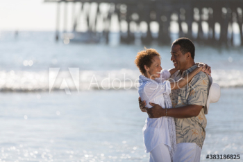 Happy active senior couple hugging on sunny ocean beach Happy active senior couple hugging on sunny ocean beach
