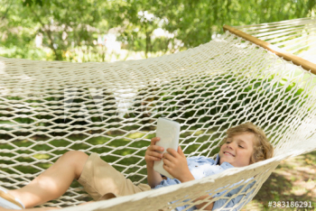 Happy boy using digital tablet in hammock Happy boy using digital tablet in hammock