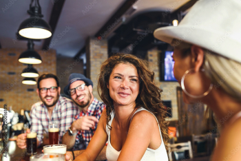 Happy friends having fun at bar - Young trendy people drinking beer and laughing together