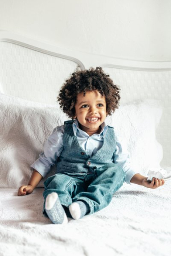 Happy Little Boy Sitting On Bed Happy Little Boy Sitting On Bed