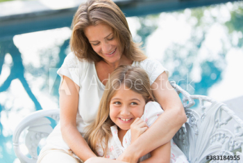 Happy mother and daughter hugging at poolside Happy mother and daughter hugging at poolside