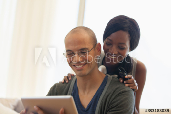 Happy multiethnic couple using digital tablet Happy multiethnic couple using digital tablet