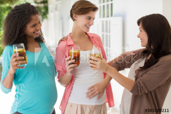Happy pregnant women friends drinking iced tea Happy pregnant women friends drinking iced tea
