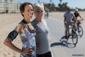 Happy senior female joggers on sunny boardwalk Happy senior female joggers on sunny boardwalk
