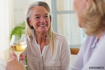 Happy senior women friends enjoying white wine Happy senior women friends enjoying white wine