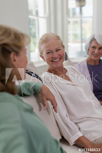 Happy senior women friends talking on sofa Happy senior women friends talking on sofa