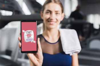 Happy sporty woman presenting smartphone mockup Free Psd