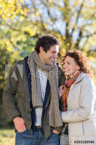 Happy young couple arm in arm in autumn park Happy young couple arm in arm in autumn park