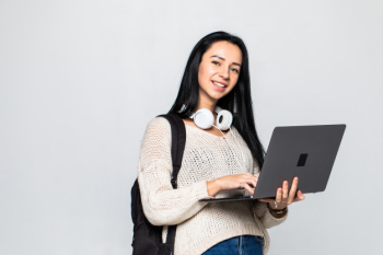 Happy young woman holding laptop and over gray wall Free Photo Happy young woman holding laptop and over gray wall Free Photo