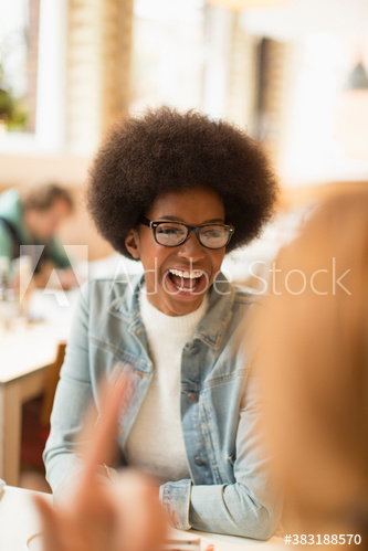 Happy young woman with afro laughing in cafe Happy young woman with afro laughing in cafe