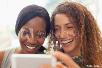 Happy young women friends using digital tablet Happy young women friends using digital tablet