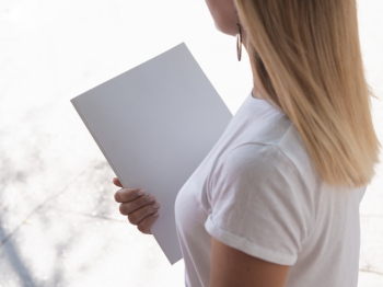 High view woman holding a mock-up magazine Free Photo