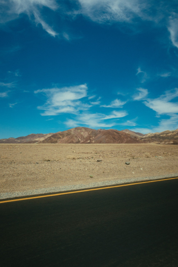 Highway Across Mountain Range Under Blue Sky Highway Across Mountain Range Under Blue Sky