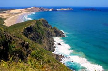 hills in front of sea during daytime hills in front of sea during daytime