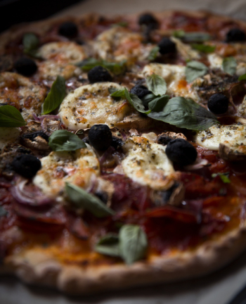 Homemade pizza with mozzarella and basil close up Homemade pizza with mozzarella and basil close up