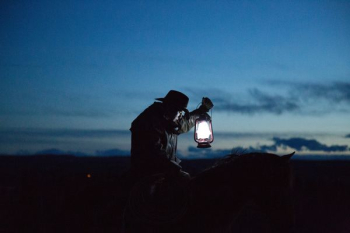 horseback riding cowboy holding a lamp horseback riding cowboy holding a lamp