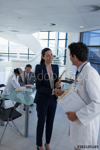 Hospital administrator shaking hands with doctor in meeting Hospital administrator shaking hands with doctor in meeting
