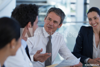 Hospital administrator talking with doctors in meeting Hospital administrator talking with doctors in meeting