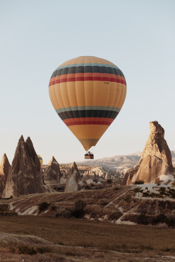 Hot Air Balloon On Mid Air Above Rock Formation Hot Air Balloon On Mid Air Above Rock Formation