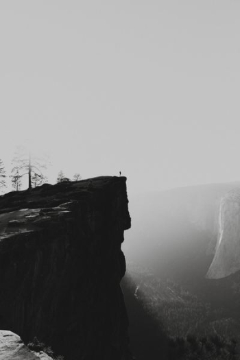 human standing on brown cliff human standing on brown cliff