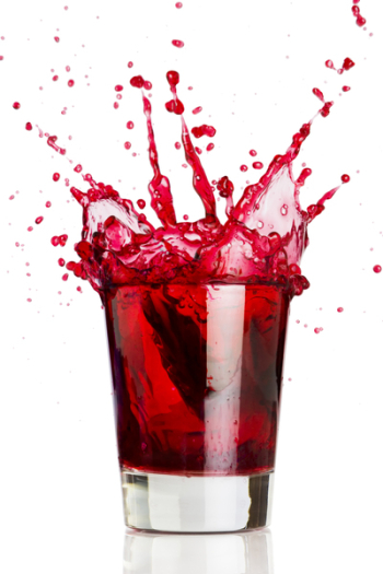 Ice cube dropped into a glass of grape juice