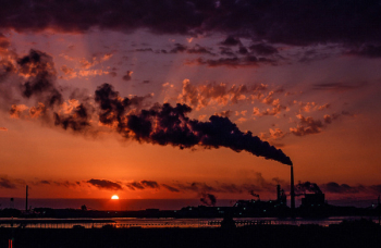 Industrial factory smoke from smokestacks over sunset sky Industrial factory smoke from smokestacks over sunset sky