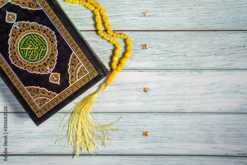Islamic Concept - Holy Quran on Wooden Background. Shallow depth of field