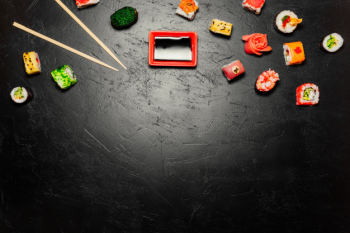 Japanese Sushi and chopsticks on black background. Sushi rolls, nigiri, maki