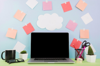 Laptop in front of wall with cloud paper and adhesive notes