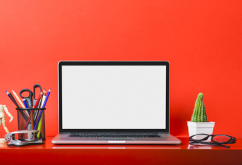 Laptop on red desk with stationeries and cactus plant Laptop on red desk with stationeries and cactus plant