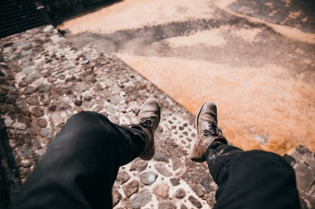 Legs Dangling Over Cobble Stone Road Legs Dangling Over Cobble Stone Road
