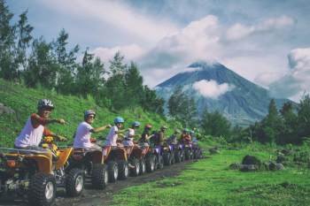 Line Of Men Riding On All Terrain Vehicles Holding Out Hand In A Fist 