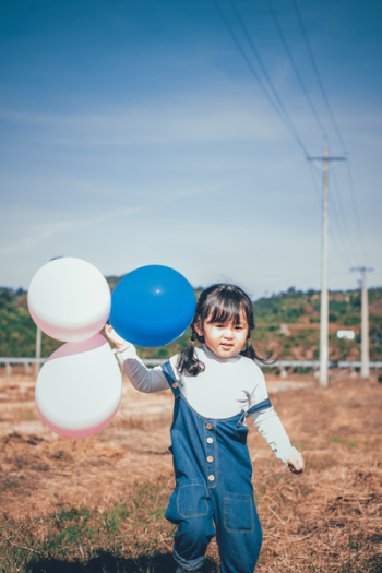 Little Girl Holding Balloons Little Girl Holding Balloons