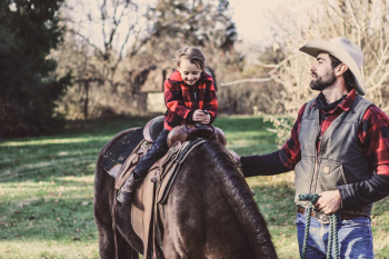Little Girl Riding Horse Beside Man Little Girl Riding Horse Beside Man